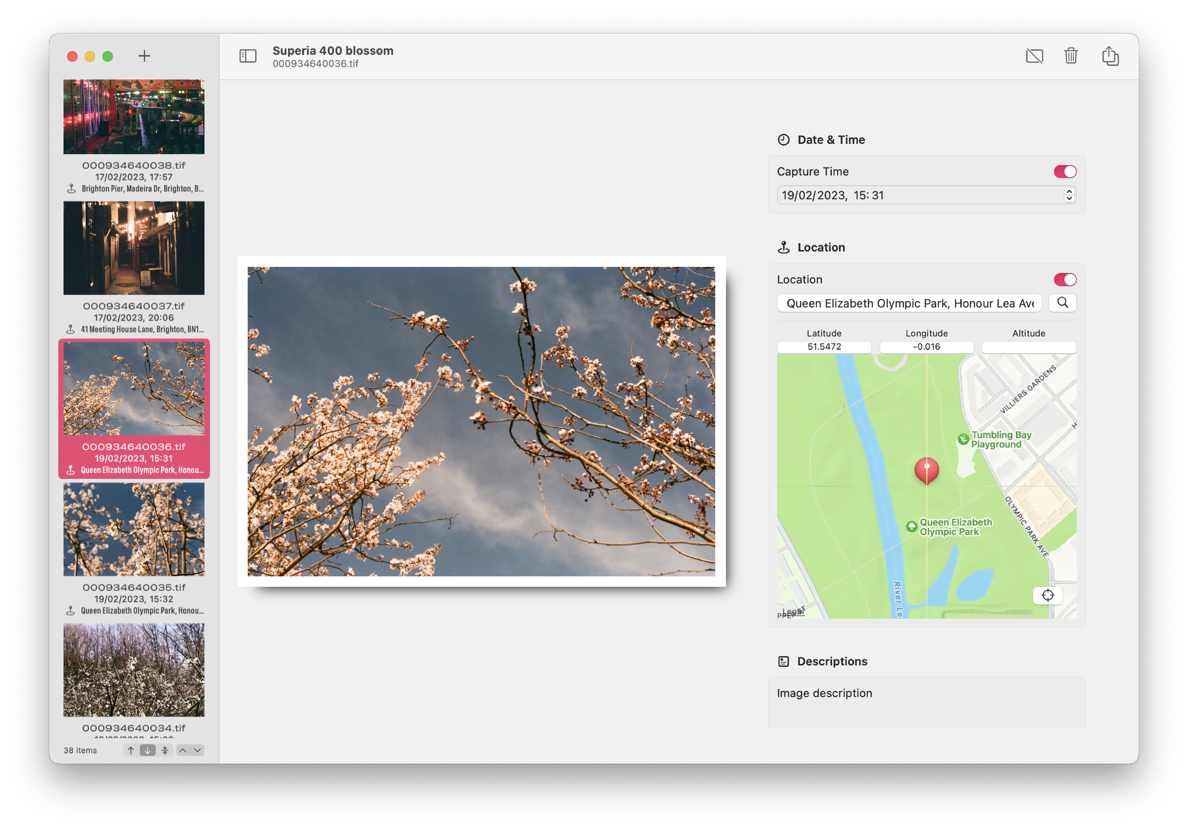 Another Unspool screenshot, this time with a photo of pink blossom on two trees against a blue sky selected. In the detail pane, the image is shown with a white border suggesting a print, alongside controls allowing the app’s user to set the capture time and the location (by searching, or by setting latitude, longitude, and altitude) along with an image description.